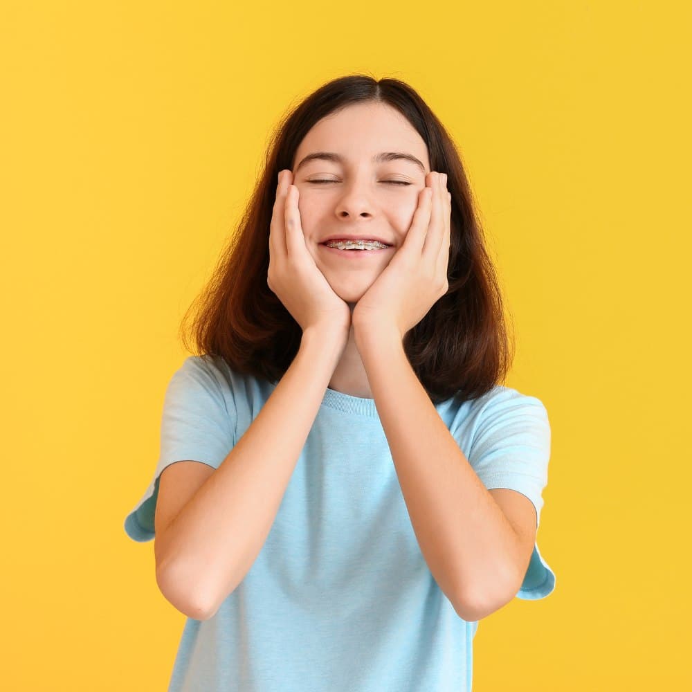 Young girl smiling with yellow background.
Oral Health