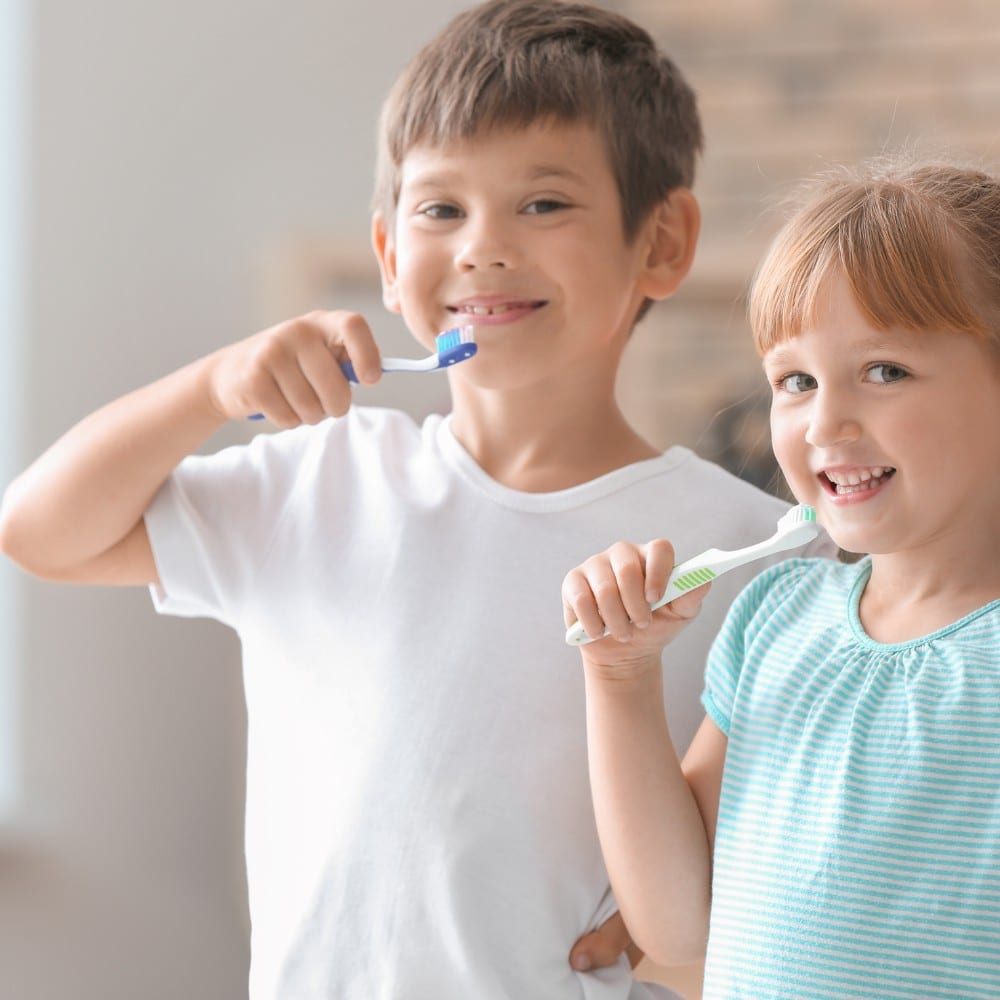 Two kids brushing their teeth.