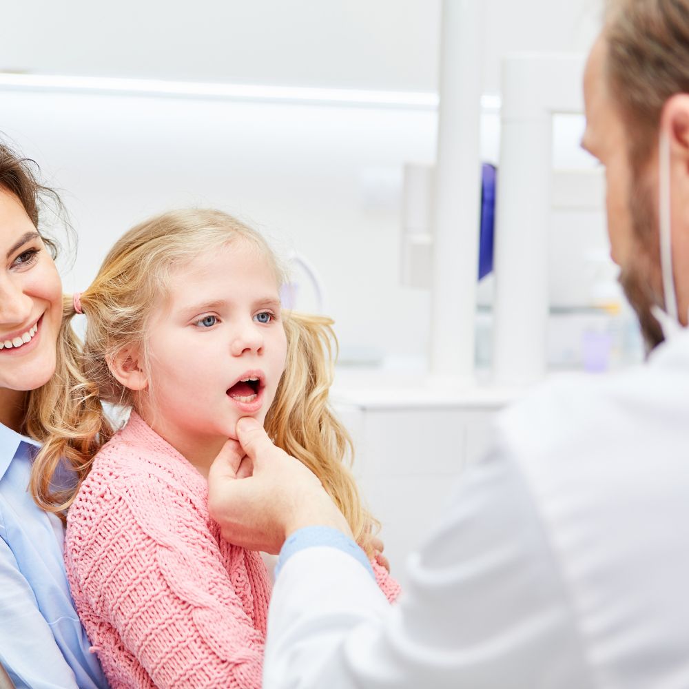 Young girl being examined by dentist.